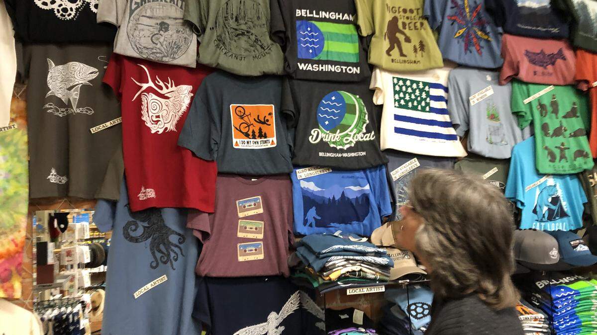 Tina Anderson looks over some of the shirts at her shop, Bay to Baker Trading Co. in Fairhaven on Dec. 6. Anderson said products with local ties, like the Bellingham T-shirts, have been selling well this holiday season.