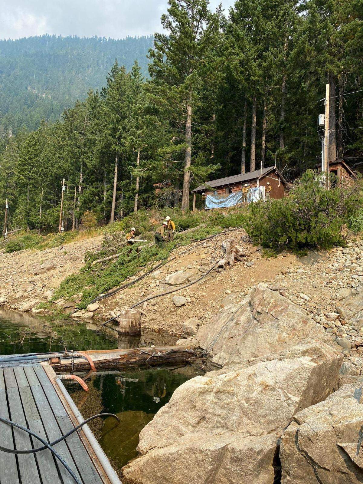 Fire crews work to protect the Ross Lake Resort from the Sourdough Fire on Tuesday.