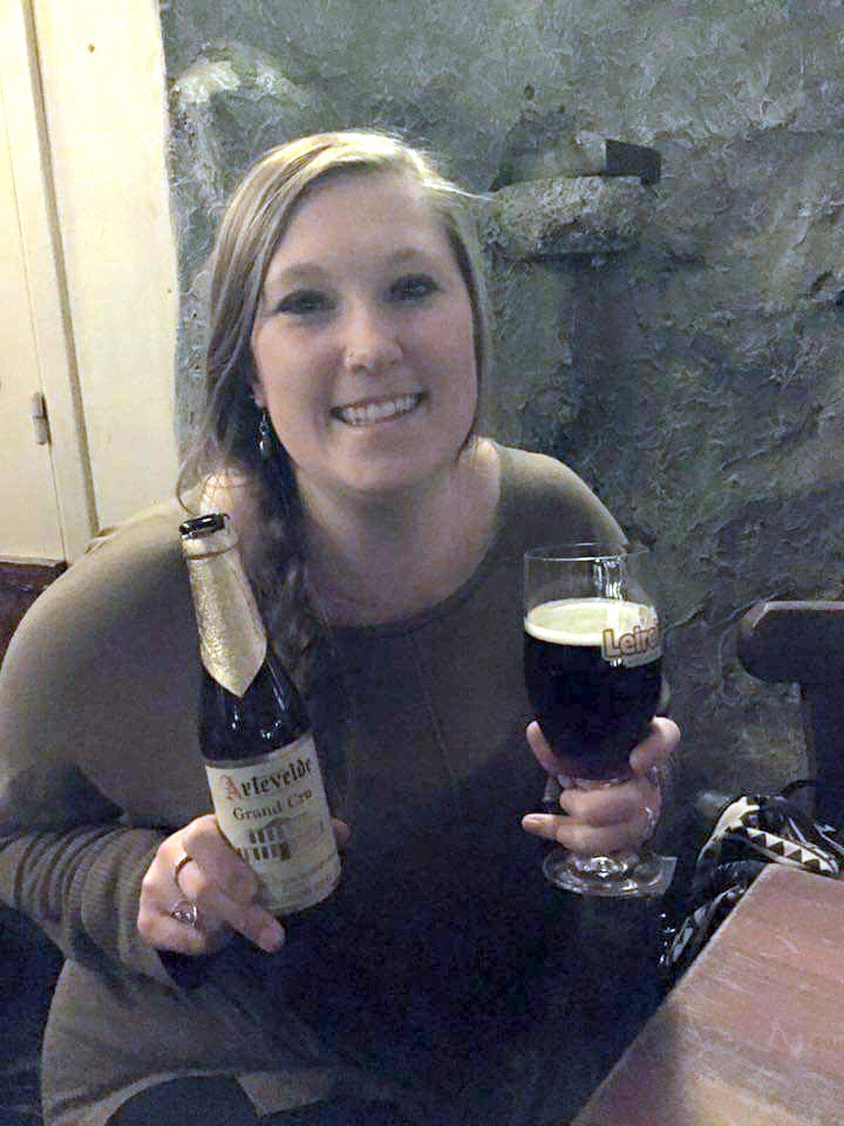 Bellingham Herald reporter Denver Pratt shows off a beer she picked at the Delirium Café, home to more than 2,000 different types of beer, in Brussels during a summer trip to Europe. 