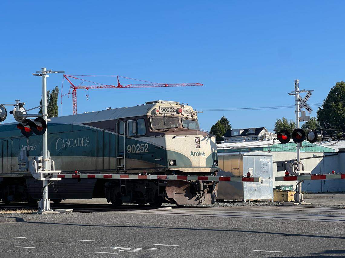 Crossing arms stop traffic as an Amtrak passenger train crosses C Street heading north on Aug. 1, 2023, in Bellingham, Wash.