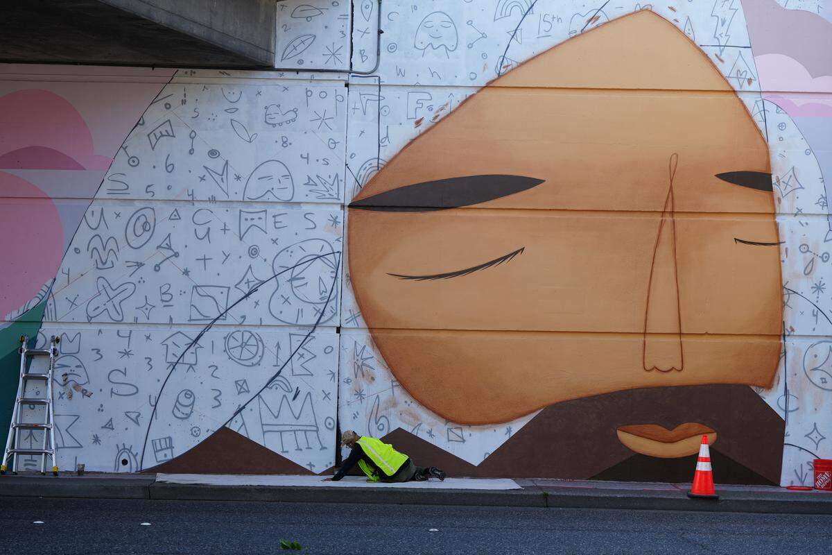 Denver-based street artist Pedro Barrios works on his new mural on Tuesday.