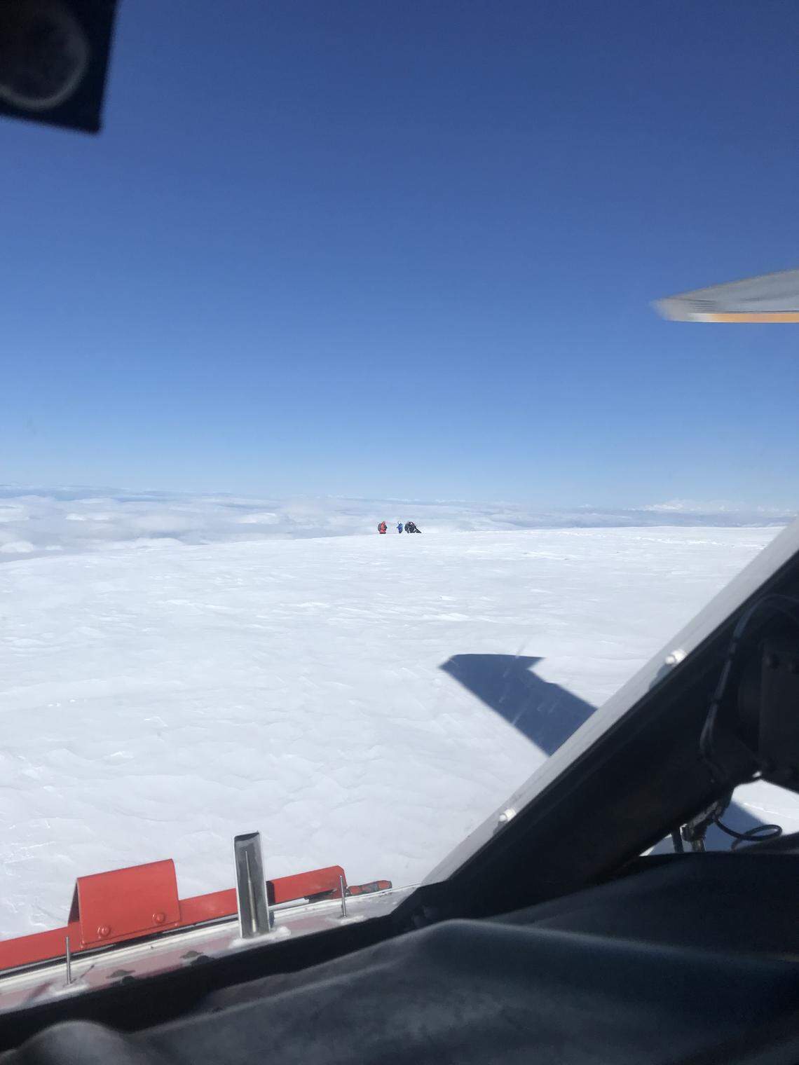 A member of the U.S. Navy's search and rescue helicopter crew, seen through the front window of the Navy helicopter, assists the missing climbers Monday morning at the summit of Mount Baker.