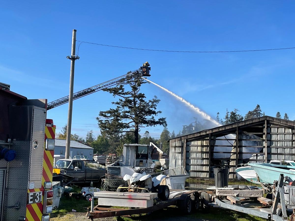 Firefighters battle a fire at a boatyard on Gooseberry Point near Bellingham on Tuesday, April 10. The fire destroyed a building and the boats and fishing gear stored inside, causing an estimated $2.5 million in damage, but no serious injuries were reported.