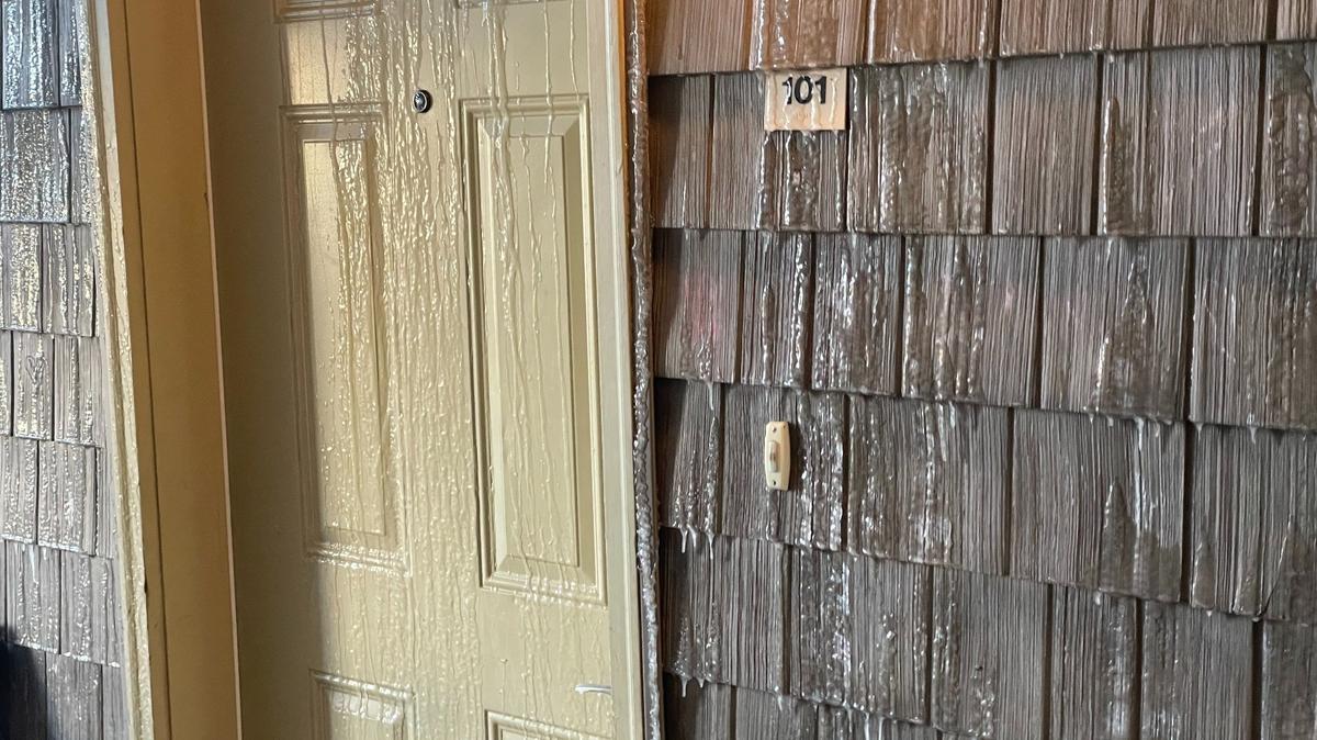 Water from a burst fire sprinkler is frozen on the exterior of an apartment door at the Meadow Wood town homes in Bellingham, Wash.