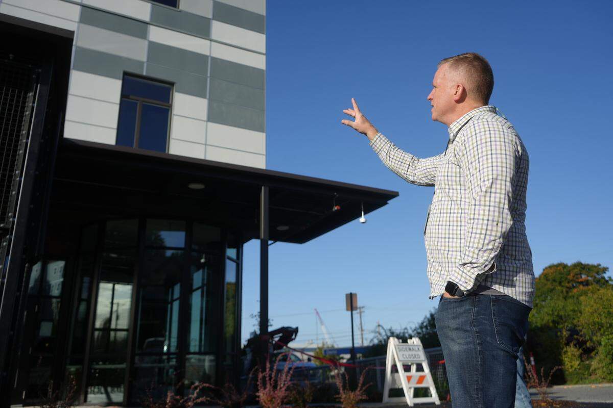 Lighthouse Mission Ministries Chief of Advancement Loran Zenonian gestures toward the outside of the organization’s newly built homeless shelter and services building at 1312 F Street on Friday in Bellingham.