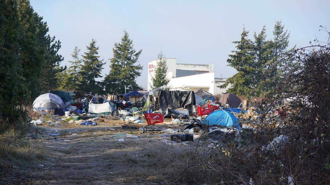Tents and temporary shelters occupy the property at 4049 Deemer Road near WinCo Foods on Friday, Dec. 16, 2022, in Bellingham, Wash. The city of Bellingham sued the property owner for allegedly causing a public nuisance by not clearing the encampment on the property.