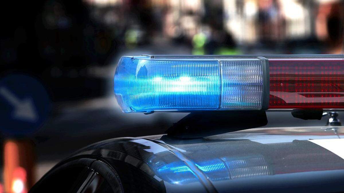 Police patrol car with flashing lights and siren on during the night raid against crime
