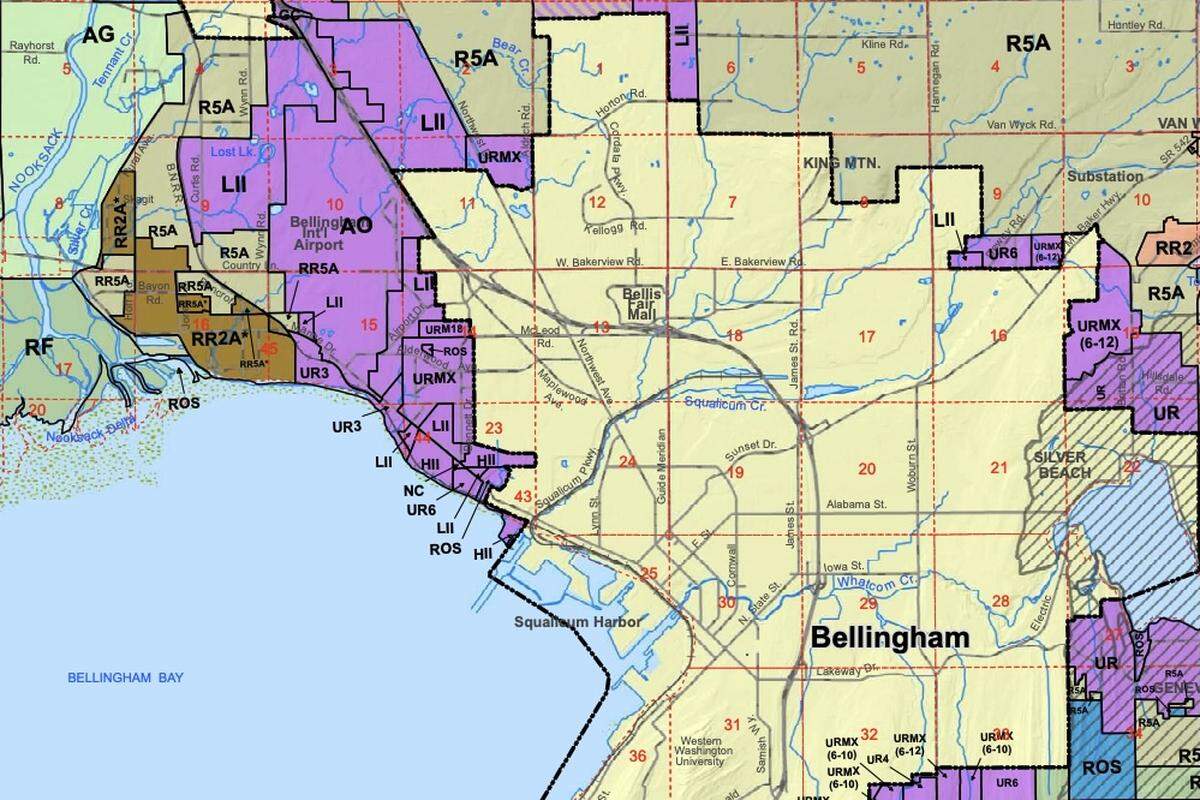 A Whatcom County zoning map shows the designated Urban Growth Area (UGA) — highlighted in purple — west of Bellingham’s city limits — highlighted in yellow — as of 2026. Areas designated Heavy Impact Industrial (HII) and Light Impact Industrial (LII) within the UGA exist along residential boundaries.