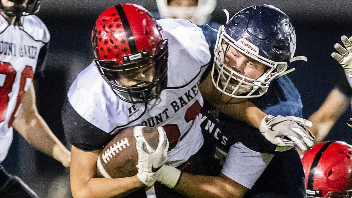 Mount Baker running back Jason Lee, left, gets pulled down by Lynden Christian linebacker Dylan Kaemingk on Oct. 12. Strength and team building forged in the Lynden Christian weight room helped propel the Lyncs to a share of their first 1A NWC title since 2001 and a Northwest District playoff date with King’s on Friday.