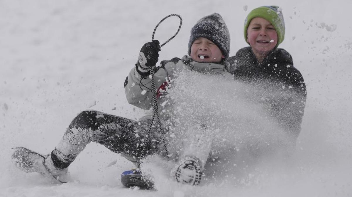 Max Jones, 11, and Cooper Graddon,11, make a hard landing while sledding down the hill at Lynden Middle School during their day off from school in February 2017. NOAA says we may have more snow days in this winter’s future.