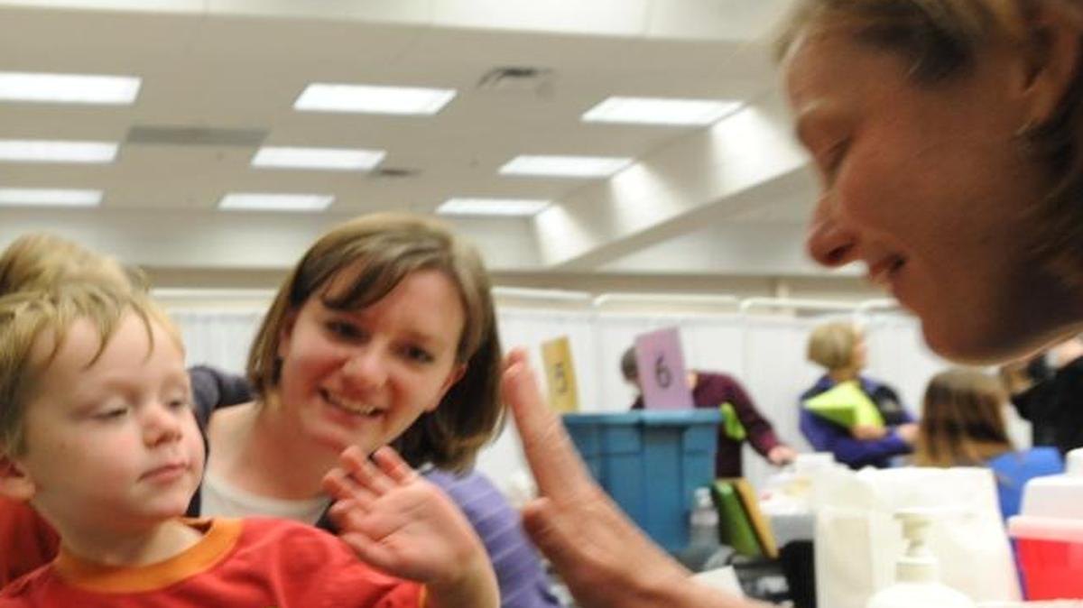 Liam Stuart, then 3, gives nurse Judy Ziel a high five after getting his H1N1 flu shot at the first mass vaccination clinic for H1N1 in Bellingham in 2009.