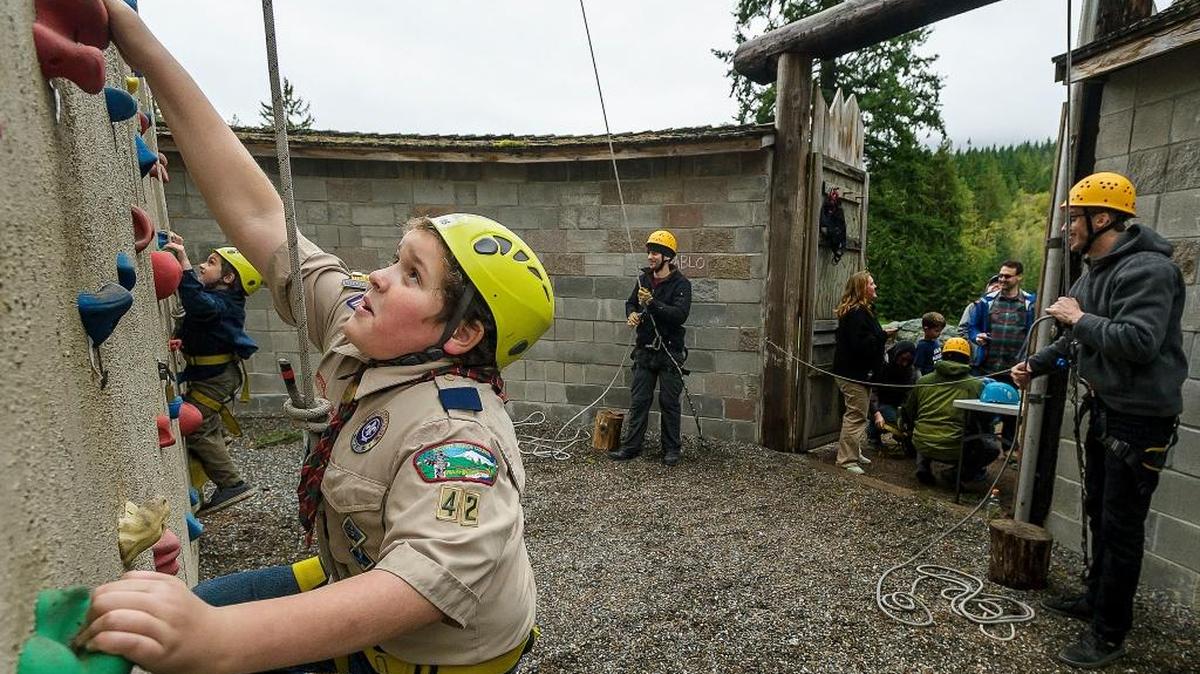 Ryan Kepley, 10, center, and his brother Jonny Kepley, 7, start their climb up the climbing wall during the Cub Scout Stampede with Ropes course as program director George Oxborrow of Bellingham and climbing director Sean Keller help on Oct. 21, 2017, at the Fire Mountain Scout Camp in Mount Vernon, Washington. The annual stampede is organized by the Boy Scouts of America Mount Baker District.