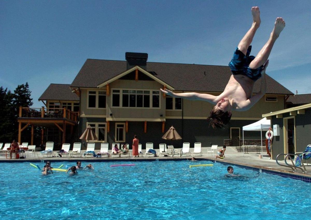 Jake Suel, then 11, of Bellingham, takes advantage of the first day of summer in 2006 by doing a front flip off the diving board at the Bellingham Golf and Country Club’s swimming pool.