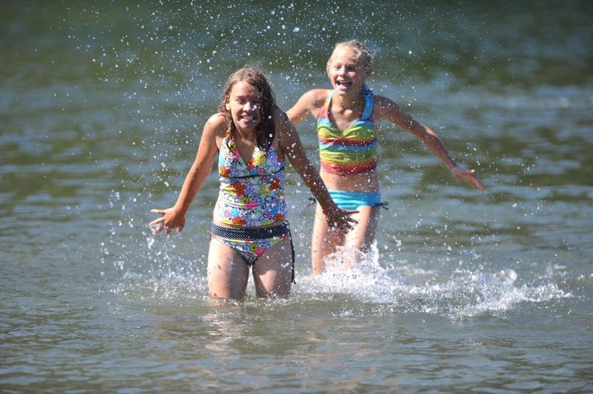 Mackenzie Nordby, then 11, of Ferndale, front, gets splashed by friend Shariece Payne, 11, of Bellingham, while enjoying a sunny day at the swimming area at Bloedel-Donovan Park in September 2011.