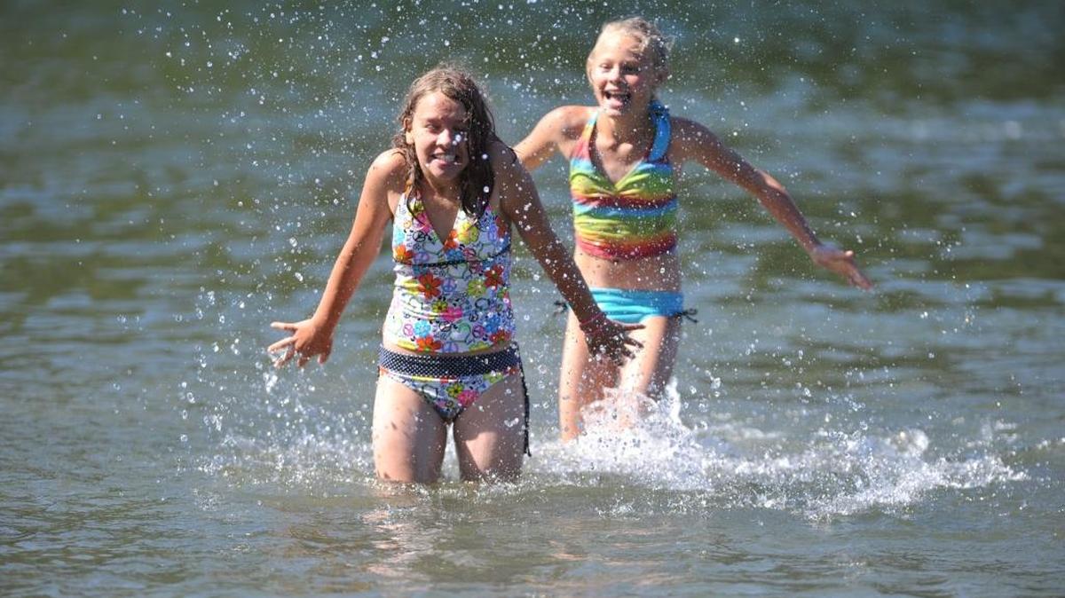 Mackenzie Nordby, then 11, of Ferndale, front, gets splashed by friend Shariece Payne, 11, of Bellingham, while enjoying a sunny day at the swimming area at Bloedel-Donovan Park in September 2011.