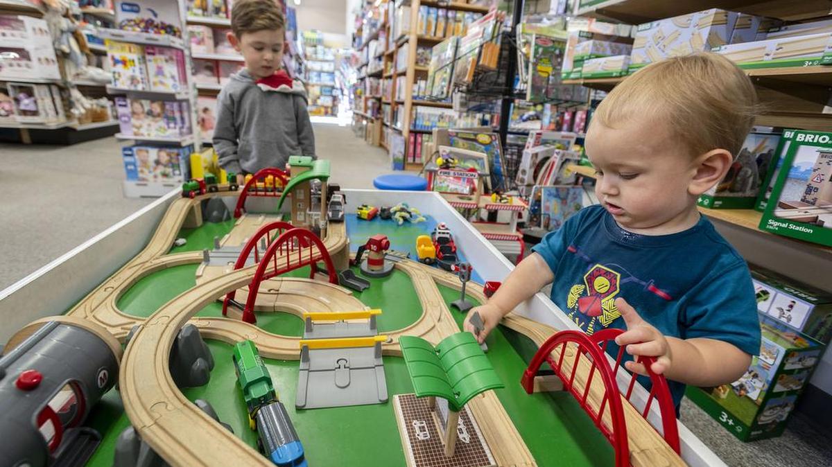 Kasyn Green, left, and Orion Watts play with a train set at the Launching Success Learning Store.