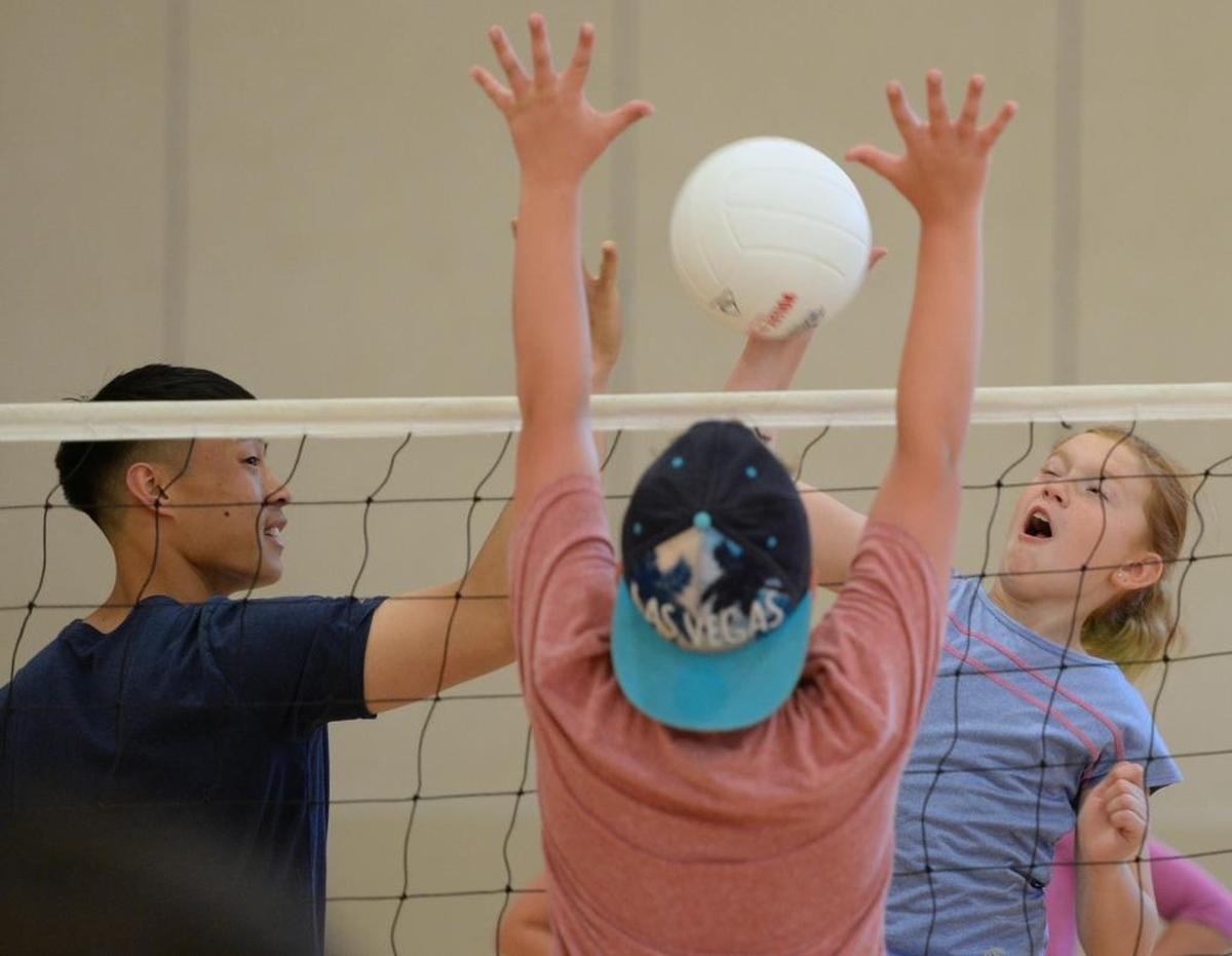 Instructor Danny Dang, left, tosses a volleyball for Taelur McClellan, 10, during the After School Enrichment volleyball class at Cordata Elementary in Bellingham, Wednesday, June 7.