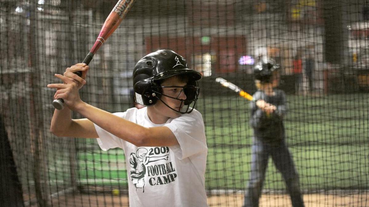 Whatcom Middle School students Eric Thompson, 13, front, and Dexer Crawford, 11, play in the batting cages at Inside Pitch in 2009.