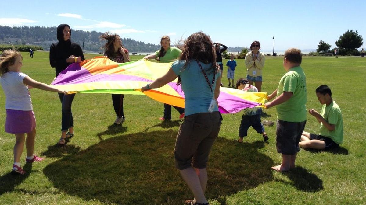 FACES Autism Summer Program students play with a parachute at Zuanich Point Park.