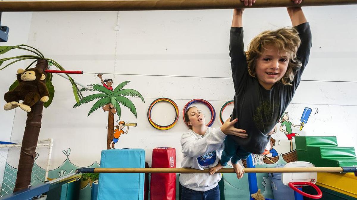 Program director and instructor Ricole Gallegos helps a student on the uneven parallel bars at Bellingham Bay Gymnastics.