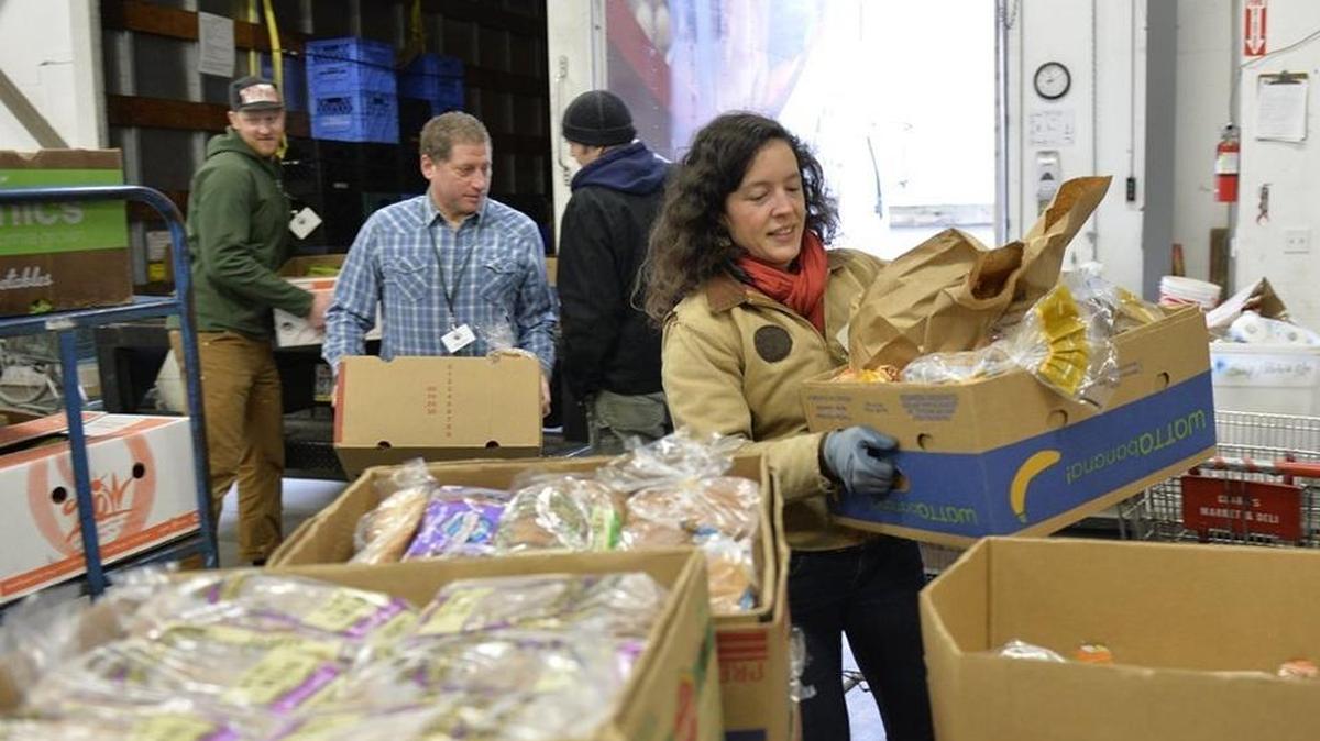 Volunteer Troy Peterson, left, executive director Mike Cohen, warehouse manager Matt Cooper and grocery rescue driver Melanie Swanson unload donations of food at the Bellingham Food Bank in Bellingham in January, 2015.