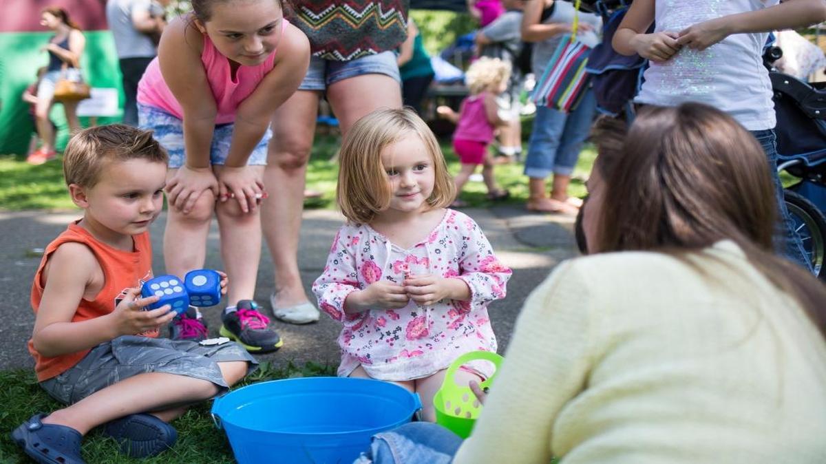 Caleb Bazett, then 4, left, Vanessa Anderson, then 7, and Mariah Anderson, then 3, listen to Natalie Smith about the prizes they could choose from candy, stickers and notepads at the 2014 Bellingham Kids Festival. The 2015 festival is Aug. 6 at Civic Field.