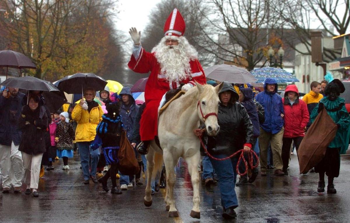 The Dutch Santa Sinterklaas rides through Lynden on horseback, leading a parade of men, women and children, who huddle under umbrellas in the rain Saturday afternoon. The Lighted Christmas Celebration begins with breakfast with the mythical figure who’s based on legendary, historical and folkloric origins based on Saint Nicholas, on Saturday, Dec. 2, at the community center, and ends with the lighted parade that evening.