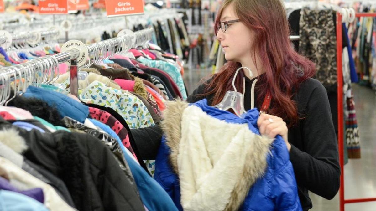 Rachel Revels hangs up girls coats at the Bellingham Value Village in November, 2015. The store stocks up coats for kids throughout the year for sale in winter months.