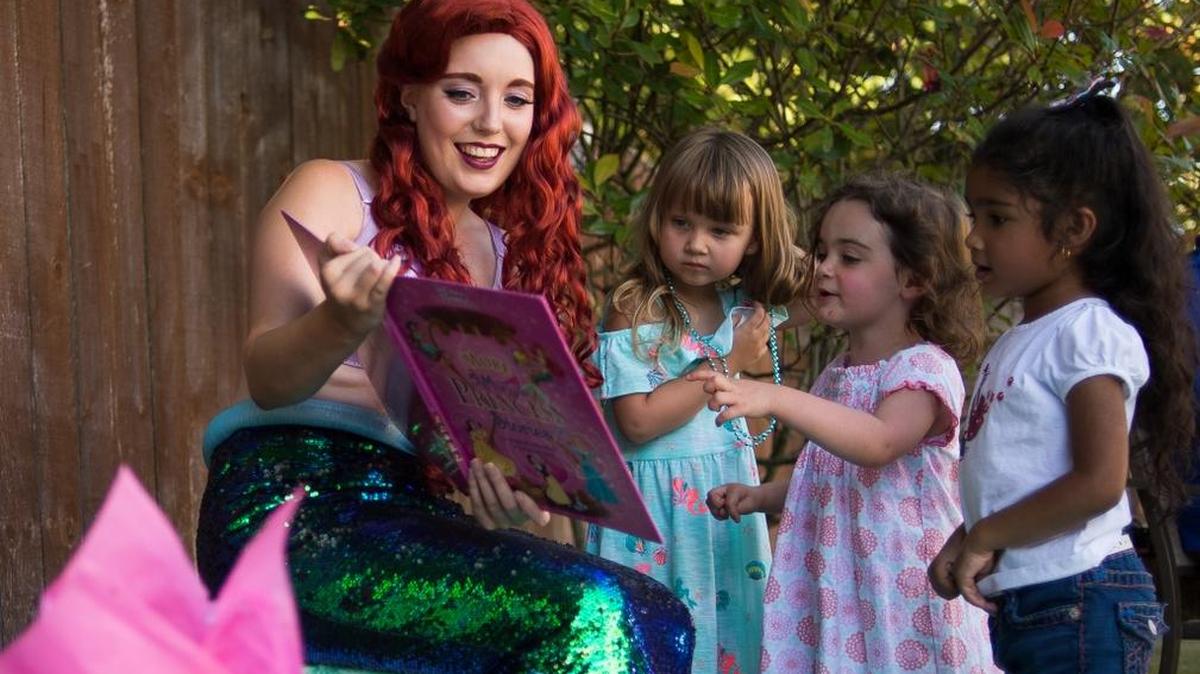 April Miller reads a story to children at a birthday party while in character as Ariel from “The Little Mermaid.” Miller started her business, When You Wish Events, after she noticed the impact fairytale characters had on children at Disneyland.