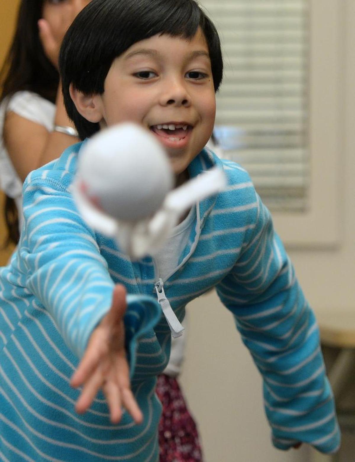 Kelani Okomunikini, 5, throws a sock puppet during a game at the After School Enrichment mixed media class at Cordata Elementary in Bellingham, Wednesday, June 7.