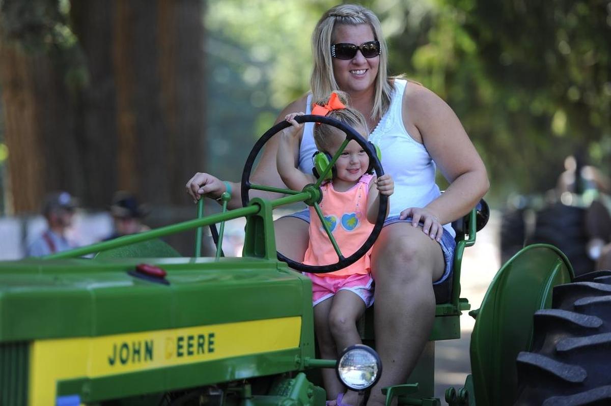 Melissa Van Beek of Lynden drives an antique John Deere tractor with her daughter Aleah Van Beek , 2, during the 44th annual tractor and machinery show put on by the Puget Sound Antique Tractor and Machinery Association in July 2015 at Berthusen Park in Lynden.
