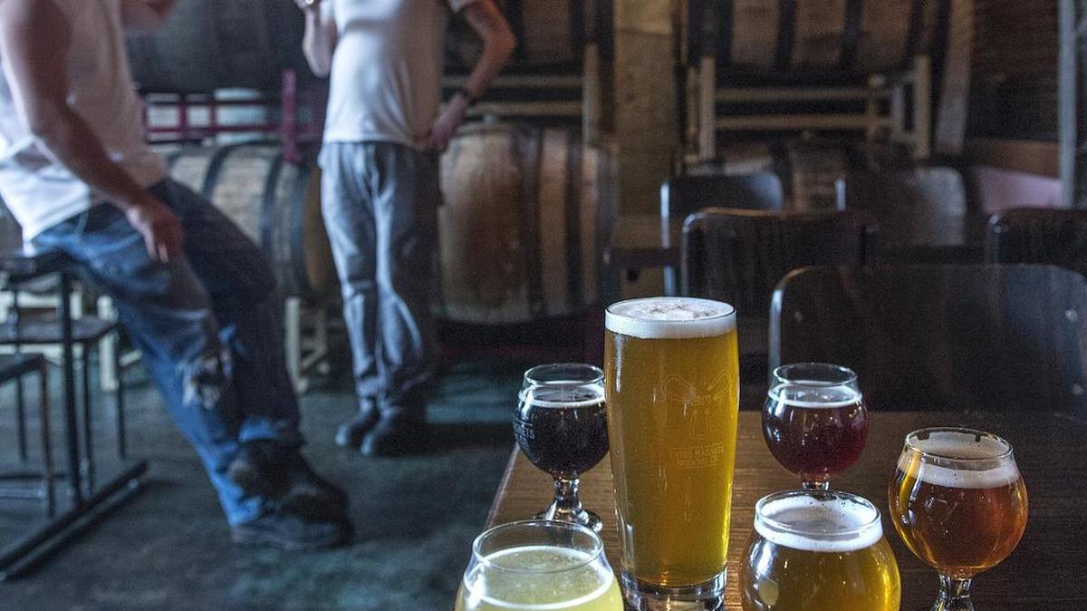 
Head Brewer Pat Jansen and brewer Jeff Stokes enjoy their work making fine craft beers and enjoy drinking their work in the Barrel Room of the Three Magnets Brewing Co. of Olympia in July.
