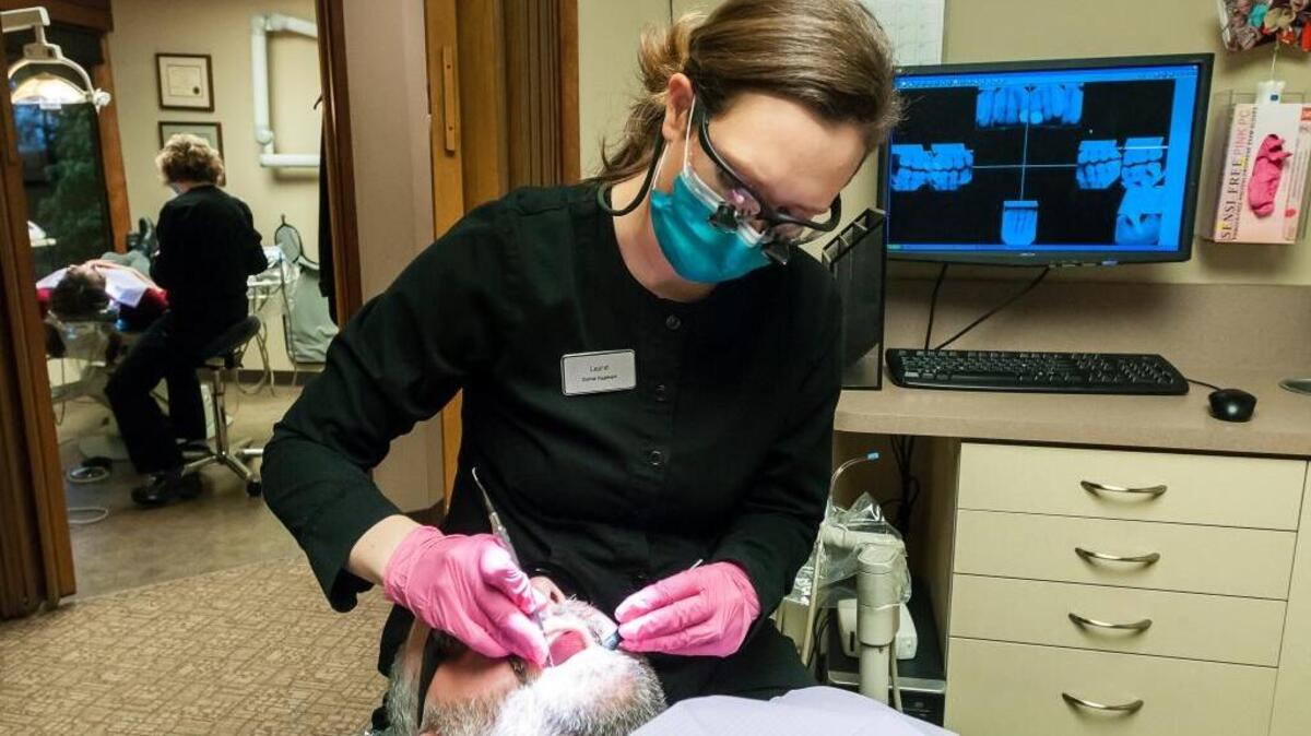 Dental hygienist Laurel Berard cleans patient Nick Strobel’s teeth at Dorsch Family Dental in Bellingham in 2016.