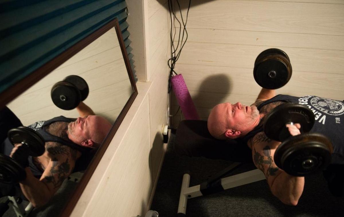 Scott Ranahan bench presses dumbbells while working out at home March 29 in Bellingham. Ranahan, who had to learn how to walk again after being hospitalized with the flu, lives with post-intensive care syndrome and works out twice a day to build and maintain his ability to move.