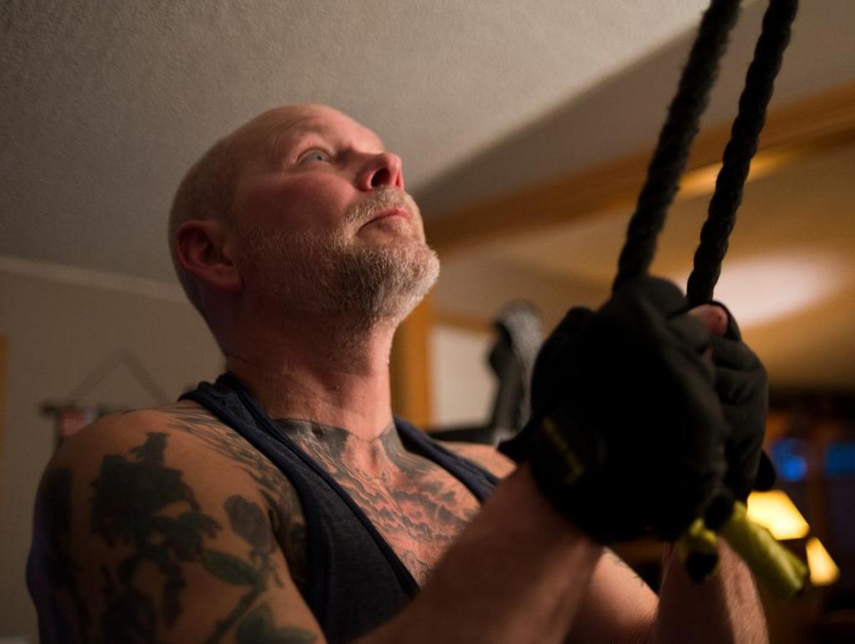 Scott Ranahan works out at home March 29 in Bellingham. Ranahan, who had to learn how to walk again after being hospitalized with the flu, lives with post-intensive care syndrome and works out twice a day to build and maintain his ability to move.