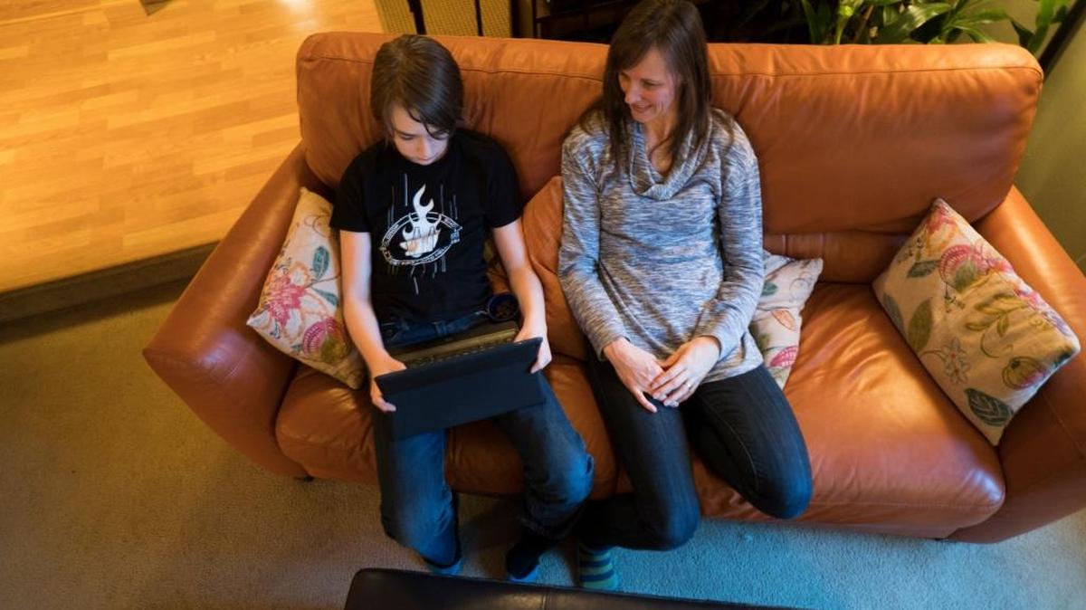 Hans Korbmacher plays a game on the family iPad as Heather Korbmacher, his mother, looks on in their Bellingham house Feb. 28. Hans struggled with a mental illness that left him almost unrecognizable until being diagnosed with PANDAS.