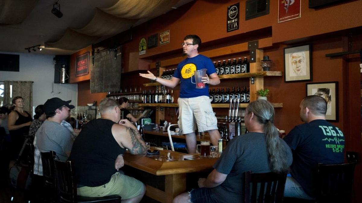 Rob Whitney, manager at The Local Public House, draws tickets for raffle prizes at the Bellingham Beer Lab launch party on July 1, 2015. The Public House is one of five locales for craft beer found within about a block of each other in corner of downtown Bellingham.