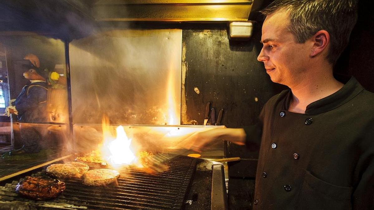 As guests watch through a window, head chef Josh McConnell works in the “broiler room” on April 1, 2016, at Herb Niemann’s Steak and Schnitzel House in Everson. McConnell says the room can be hotter than 100 degrees.