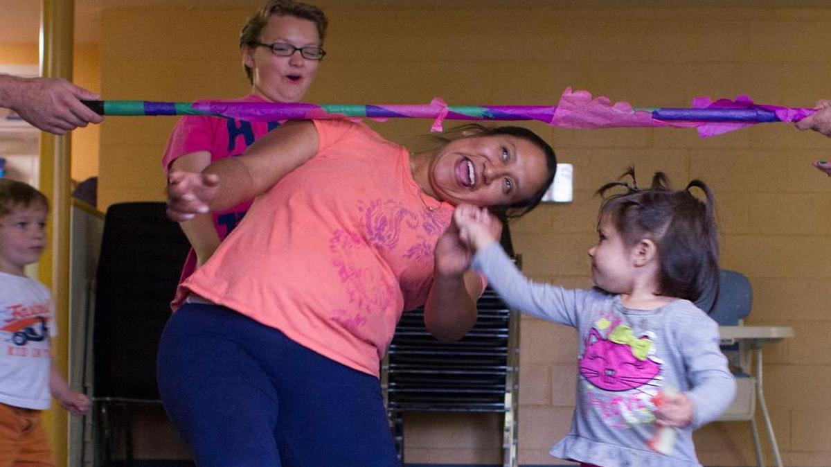 
Angeles Carmona and her daughter Ashley limbo together during the “Family Activity Night” June 18, 2015, at Brigid Collins Family Support Center in Bellingham. The quarterly event is designed to bring families together, says Ramona Slagle, a case manager at the center.
