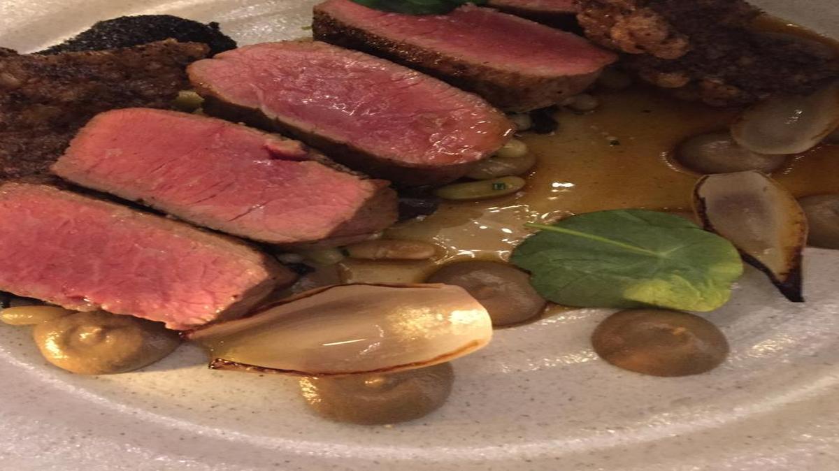 Dinner entrees at Hawksworth Restaurant in Vancouver, B.C., include roast saddle of lamb with fava beans, seared onions, and nasturtium leaves.