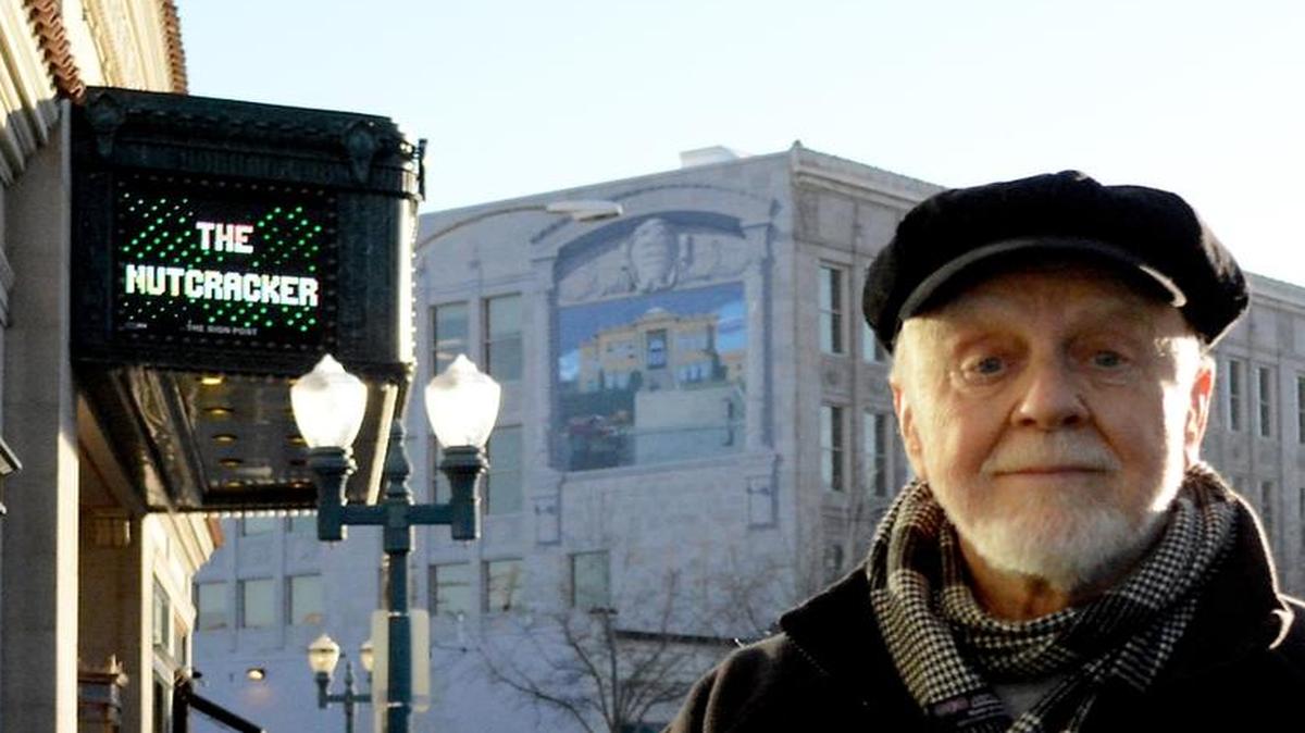 Lanny Little, the creator of several public murals in Bellingham, including the one visible behind him on the Crown Plaza building, has turned his energy to making videos about local history and artists.