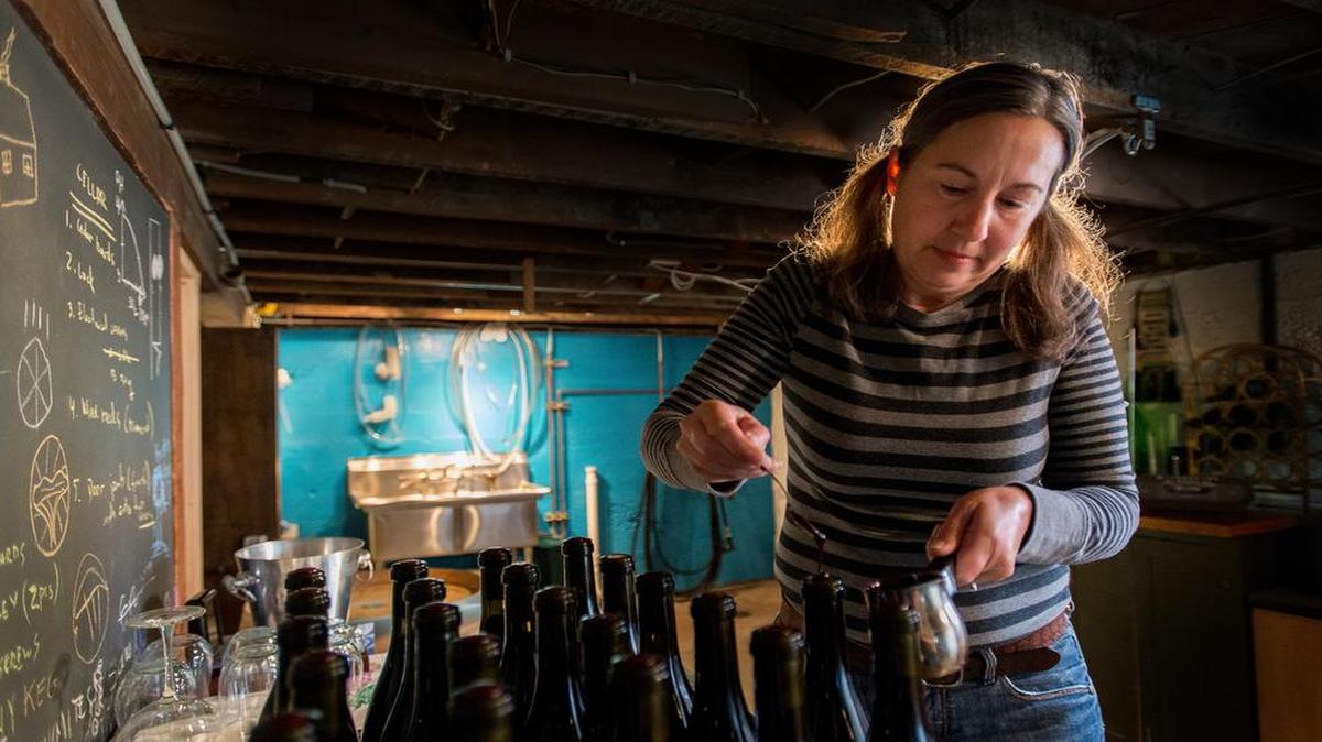 
Lotte Freeman applies wax to seal the tops of wine bottles in July 2015 at La Chanterelle Winery in Bellingham. The winery, operated by Freeman and her partner, Donatas Pocus, is in the basement of their house in the Lettered Streets neighborhood.
