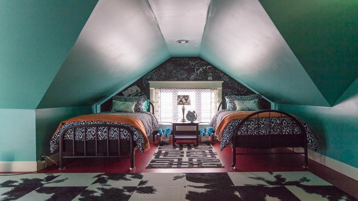 Jennifer Ryan redecorated a third-floor open space in her Bellingham house in 2014 to provide extra beds for visitors. The space had suffered a fire years ago and only had bare plasterboard before she fixed it up. She chose seafoam green paint for the walls and ceiling, and barn-red paint with cow-print carpet squares for the floor. The blackboard surface by the window lets visitors write their names and other messages. “I wanted this area upstairs to be fun and whimsical,” Ryan says.