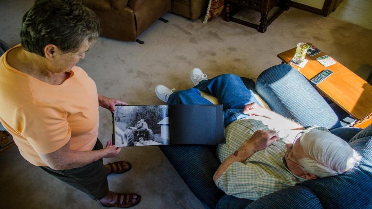 While in their Acme home April 1, 2016, Henry Maleng and his wife, Vivian, look at a photo of him and his father riding a 1944 Case tractor. Maleng is a retired logging truck driver and fire commissioner,