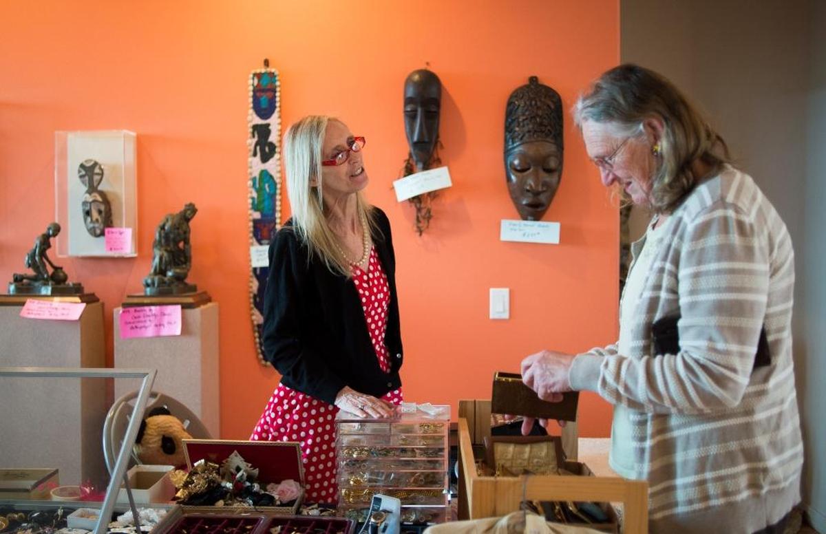 Debbie Sofka, left, helps a customer at an estate sale put on by EarthaKittys in Bellingham.