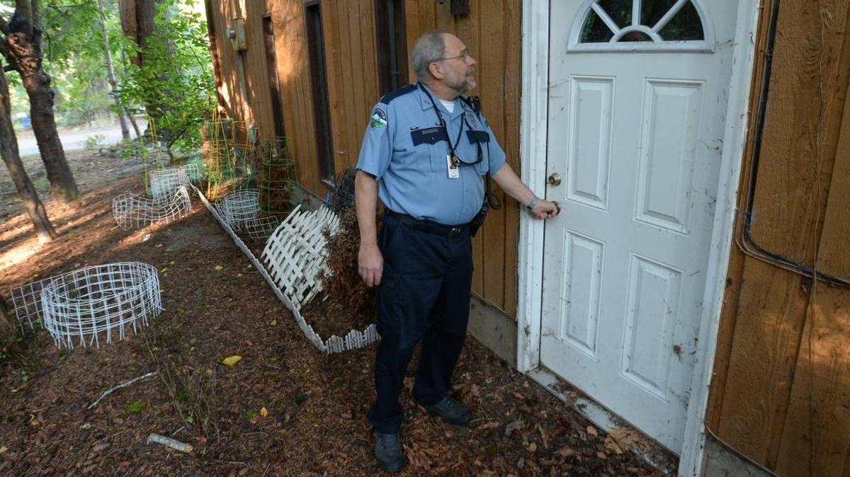 Bellingham Police Department Retired Senior Volunteer Program member Jim Tragesser, 72, checks a Bellingham home where the homeowners are on vacation.