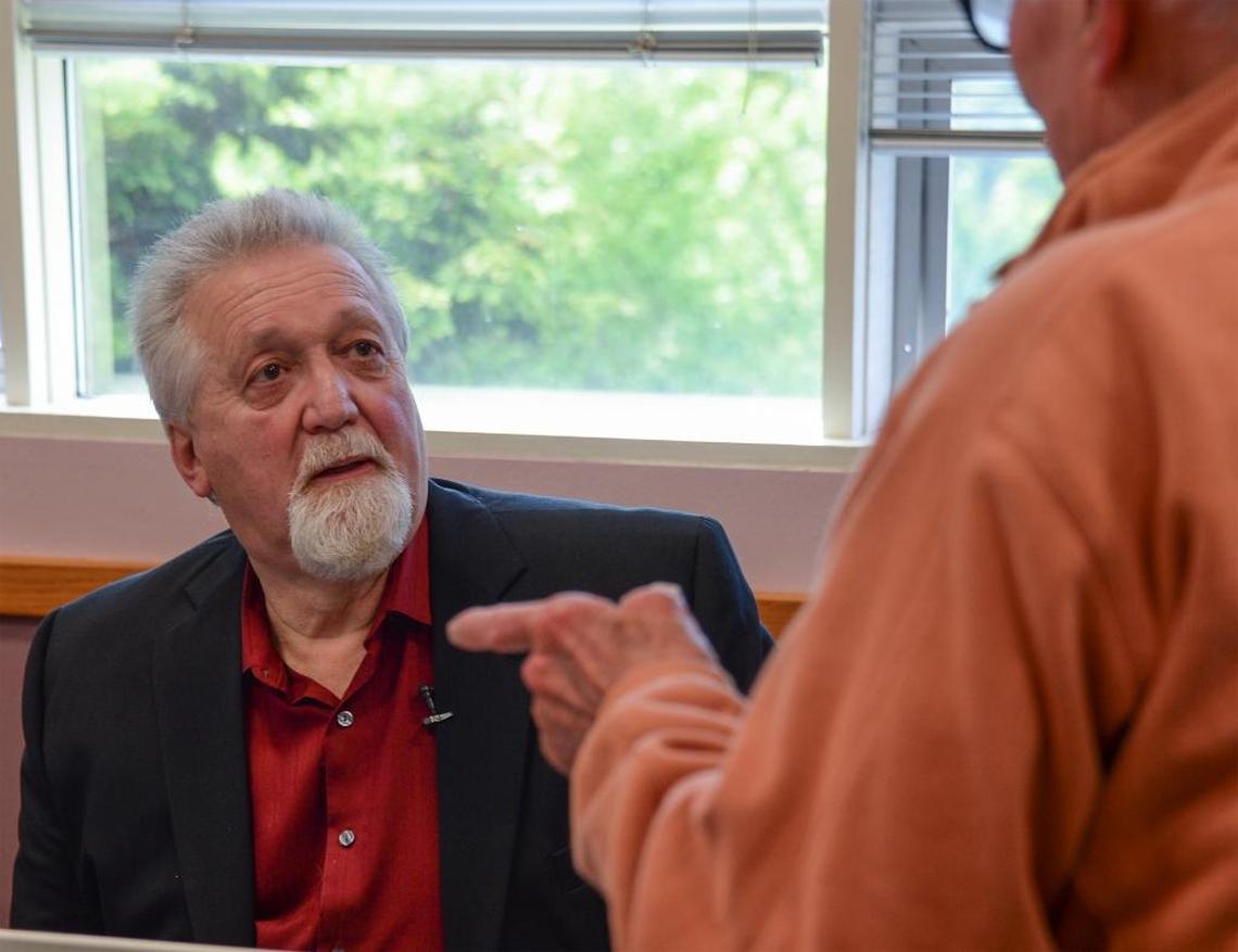 George Edward, author of “How to Steal from Mom, A Wake up Call for Seniors,” talks to senior Bob Sanders after giving a talk at the Bellingham Senior Center May 10, 2017. The people who commit such crimes target older people, Edward says, because they are most likely to have substantial savings and excellent credit.
