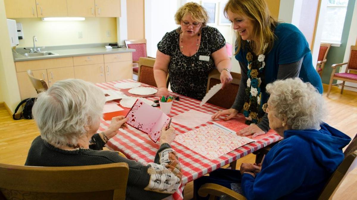 Memory-care activity leaders LeAnn Johnson and Julie Klos, center, help residents of Spring Creek in Bellingham make paper valentines on Jan. 23, 2016.