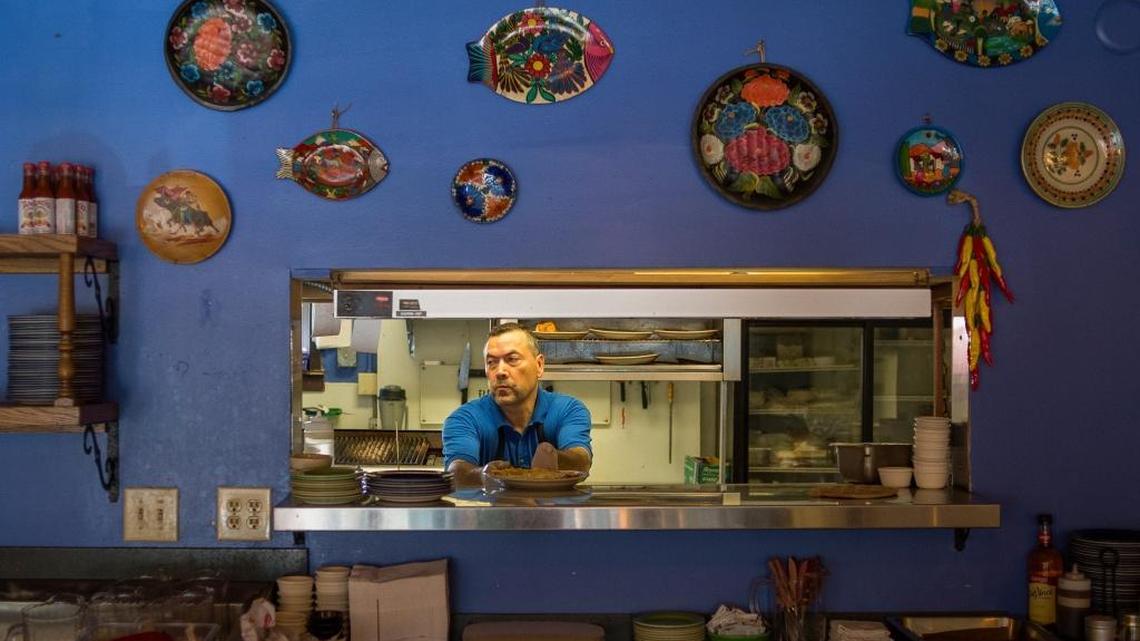 Felipe Guitron sets a plate of enchiladas in the pass-through window at the new El Agave location in Fairhaven on Wednesday, Sept. 13.