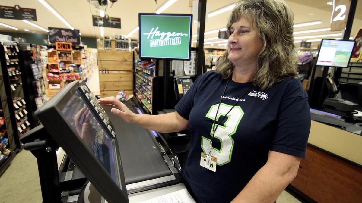 Gig Harbor Haggen store checker and 35-year employee Terri Carley logs in to her check stand on Friday morning. Carley is part of a small group that has worked at the store for more than 20 years.